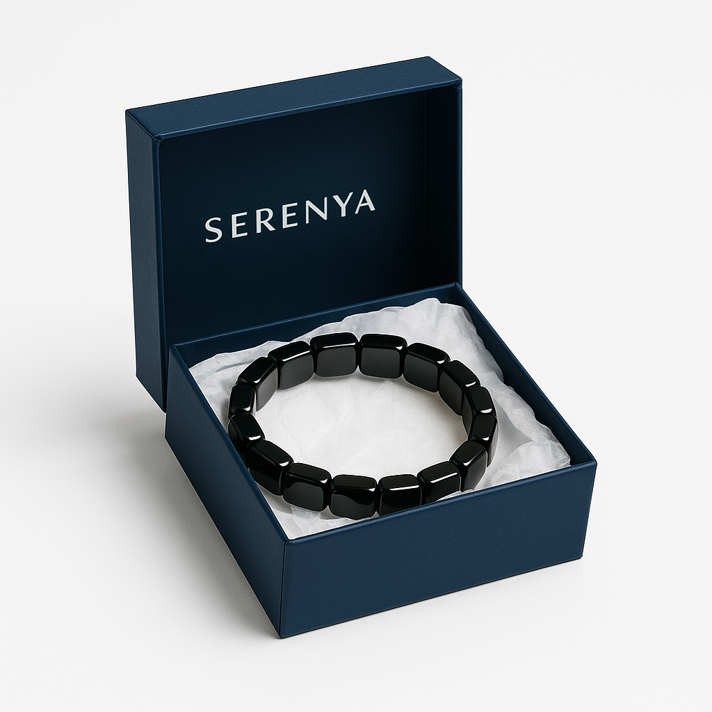 Bracelet hématite Serenya dans son écrin bleu sur fond blanc, présenté sur un lit de papier coussin.