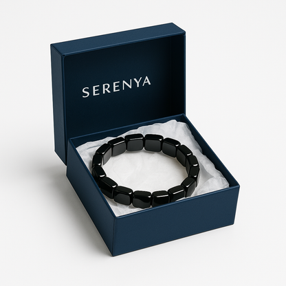 Bracelet hématite Serenya dans son écrin bleu sur fond blanc, présenté sur un lit de papier coussin.